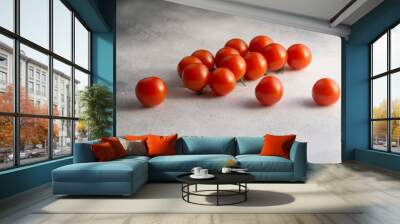 Bunch of cherry tomatoes on white stone concrete table, side view with copy space. Ingredients for cooking. Wall mural