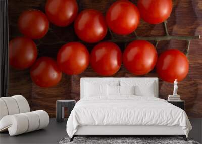 Fresh tomatoes lying on carved wooden cutting board. Top view with copy space. Wall mural