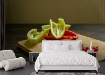 Sliced red and green bell peppers on a wooden cutting board. Organic food and coocking. Wall mural