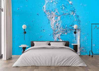 splash of pure water in a glass on a blue background Wall mural