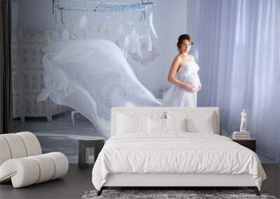 beautiful pregnant woman in white dress at the tender interior Wall mural