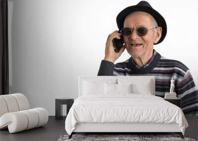 Heated discussion. Old toothless man in sunglasses and black hat having a conversation on the phone and gesticulating emotionally while posing isolated on a white background Wall mural