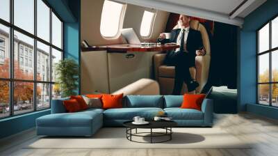 Businessman in private jet Wall mural