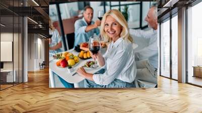 Senior friends having dinner at home Wall mural