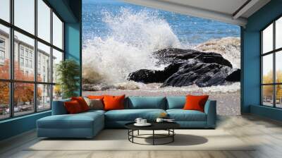 Splashes of water hitting the rocks on the ocean shore Wall mural