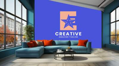 Orange negative space star on letter E logo ini blue background Wall mural