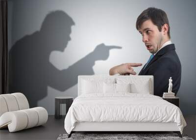 Shadow of man is pointing and blaming businessman. Conscience concept. Wall mural