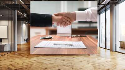 Shakehand of lawyer and business woman sitting behind desk with agreement on blurred background. Wall mural