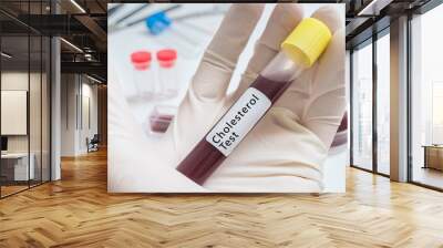 Test tube for Cholesterol test in hand. Wall mural