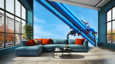 Blue water power tubes in front of blue sky Wall mural