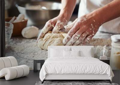 A baker's hands kneading dough on a floured countertop, with baking ingredients scattered around. Wall mural