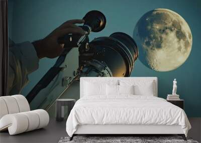 A close-up of an astronomerâ€™s hand adjusting a telescope under the glow of the moon. Wall mural