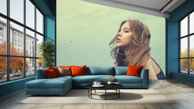 beautiful young girl in a windy day against the sky Wall mural