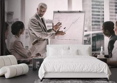 Businessman in front of a growing chart during a meeting Wall mural