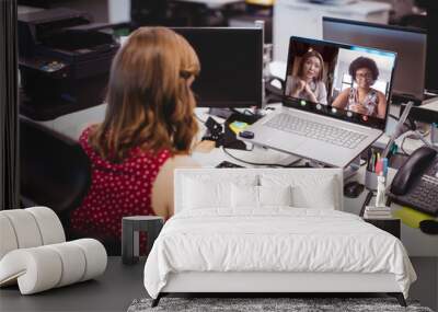 Caucasian female professional holding coffee cup video conferencing with colleagues over laptop Wall mural