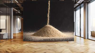 Close up of sand pouring into heap and copy space on black background Wall mural