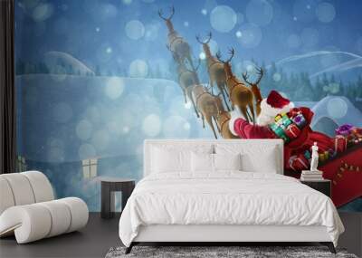 Composite image of high angle view of santa claus riding on sled Wall mural