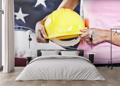 Composite image of woman holding hard hat against grey Wall mural