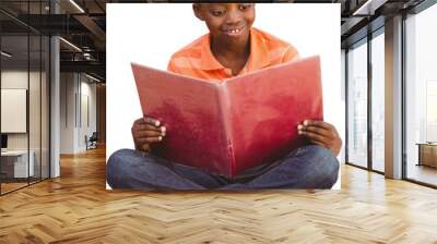 Cute boy reading book in library Wall mural