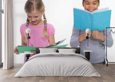 Digital png photo of two diverse girls reading from notebooks on transparent background Wall mural