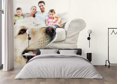 Happy family sitting on couch with their pet yellow labrador in Wall mural