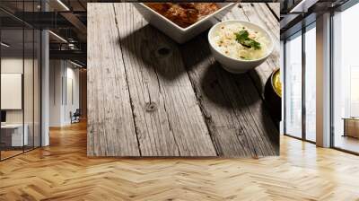 High angle view of rice with meat gravy and lentils served in bowls on wooden table Wall mural