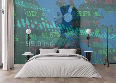 Image of graphs, map, trading board, biracial woman wearing hijab listening to music Wall mural