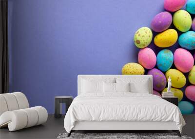 Image of multi coloured chocolate easter eggs with copy space on purple background Wall mural