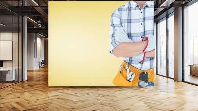 Mid section of handy man standing with arms crossed Wall mural