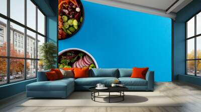 Overhead view of two hawaiian poke bowls with copy space on blue background Wall mural