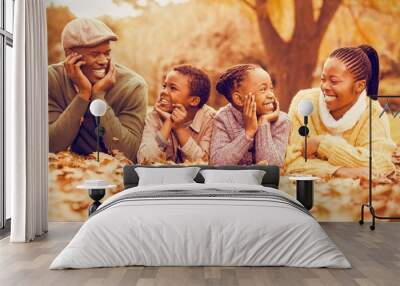 Portrait of a young smiling family lying in leaves Wall mural