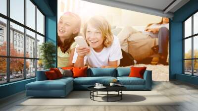 Siblings lying on the floor watching tv Wall mural