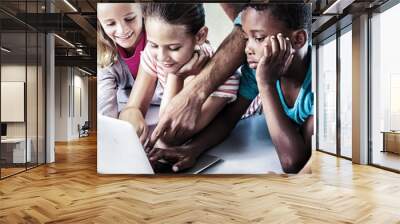 Teacher and children using laptop in library Wall mural