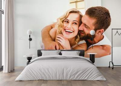 Young couple embracing on bed Wall mural