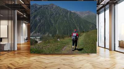 Senior woman hiking in Ala Archa National Park in Kyrgyzstan Wall mural