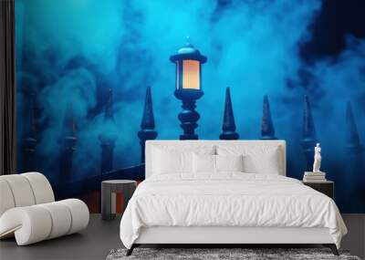 A mysterious scene featuring a lantern glowing amidst eerie blue fog, surrounded by ornate fencing. Wall mural