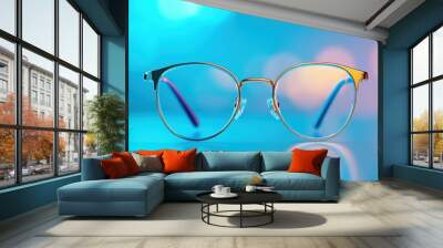 Stylish eyewear with colorful lenses against a vibrant blurred backdrop, perfect for fashion and accessory themes. Wall mural