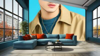 Stylish young man in sunglasses and casual attire against a bright blue background, exuding confidence and modern fashion. Wall mural