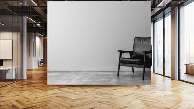 A black leather chair sits in a room with a white wall. The chair is the only piece of furniture in the room, and it is positioned in the center of the space. The room appears to be empty Wall mural