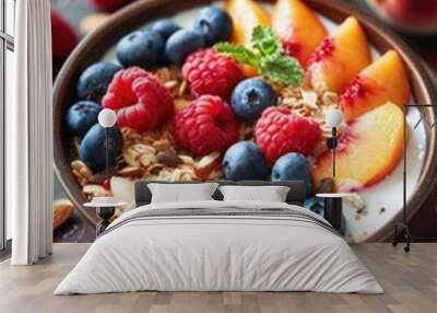 A bowl of fruit with blueberries, raspberries, and peaches. The bowl is brown and has a spoon in it Wall mural