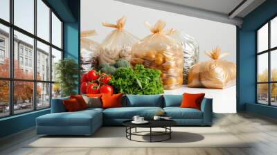 A bunch of plastic bags with vegetables in them. The bags are of different sizes and colors. The vegetables include broccoli, tomatoes, potatoes, and carrots Wall mural