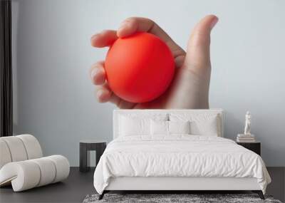 A hand holding a red ball Wall mural