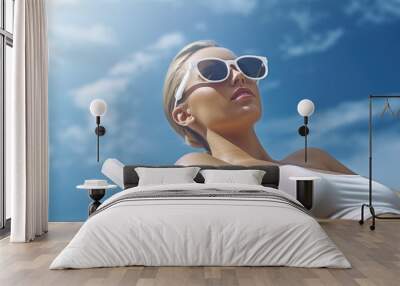 A woman relaxing on a sunny beach with a white bikini and sunglasses, ideal for travel or summer themed projects Wall mural