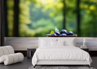 Bowl of fresh plums sitting on rustic wooden table. Perfect for food and nutrition-related content. Wall mural