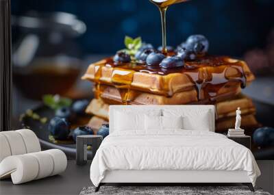 delicious waffles adorned with generous serving of juicy blueberries. To enhance their sweetness, drizzle of golden honey cascades down fluffy, creating delectable combination of flavors Wall mural