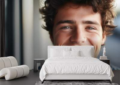 Picture of young man with curly hair smiling directly at camera. This image can be used for various purposes, such as advertising, social media, or personal projects. Wall mural