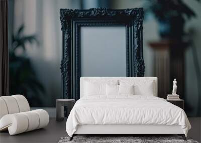 This image features an empty, ornate black picture frame with a simple glass mirror inside it. The frame is set on a table and suggests a modern style with a vintage touch. Wall mural