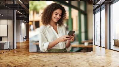 Woman is seen focused on her cell phone. This image can be used to depict modern technology usage and digital communication. Wall mural