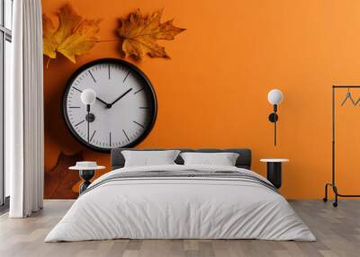 Daylight saving time ends. Black clock on orange background with autumn leaves. Summer time end and fall season coming. Clock turn backward to winter time. Autumn equinox Wall mural