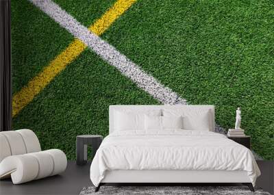 Green artificial grass turf soccer football field background with white and yellow line boundary. Top view Wall mural